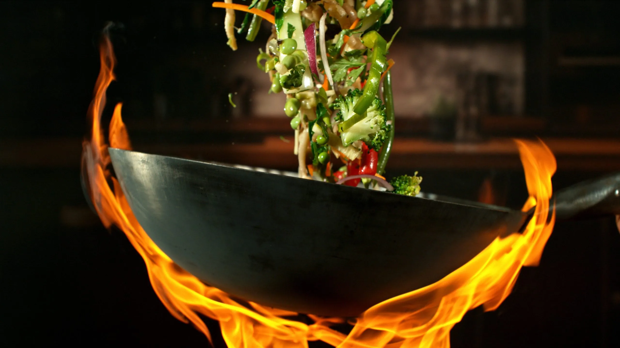 Wok stir-frying colorful vegetables over open flame at Chef Gong Chinese Restaurant in Lansing